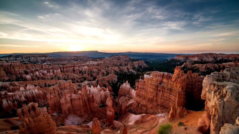 stunning view of Bryce Canyon National Park at sunrise, showcasing its unique red rock hoodoos and expansive landscape